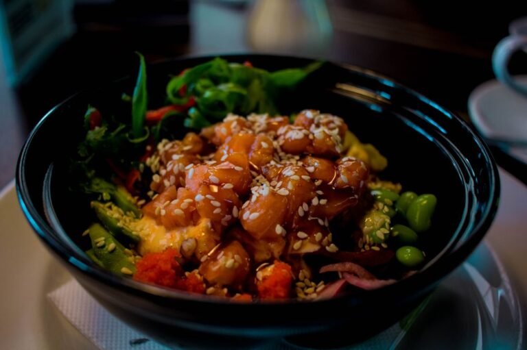 Poke bowl garni de saumon mariné, légumes et graines de sésame