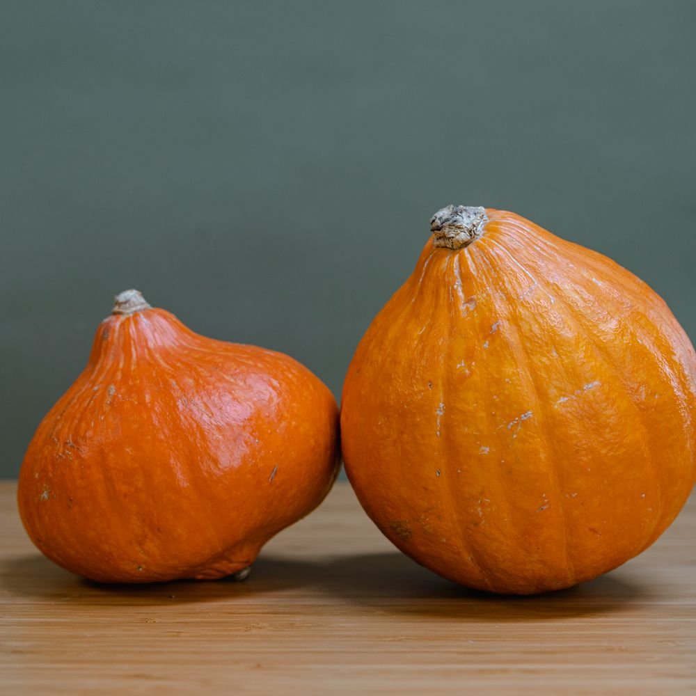 Deux potimarrons orange posés sur une table