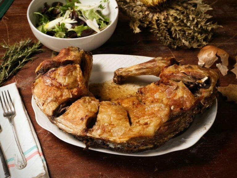 Agneau rôti servi sur une table rustique avec une salade