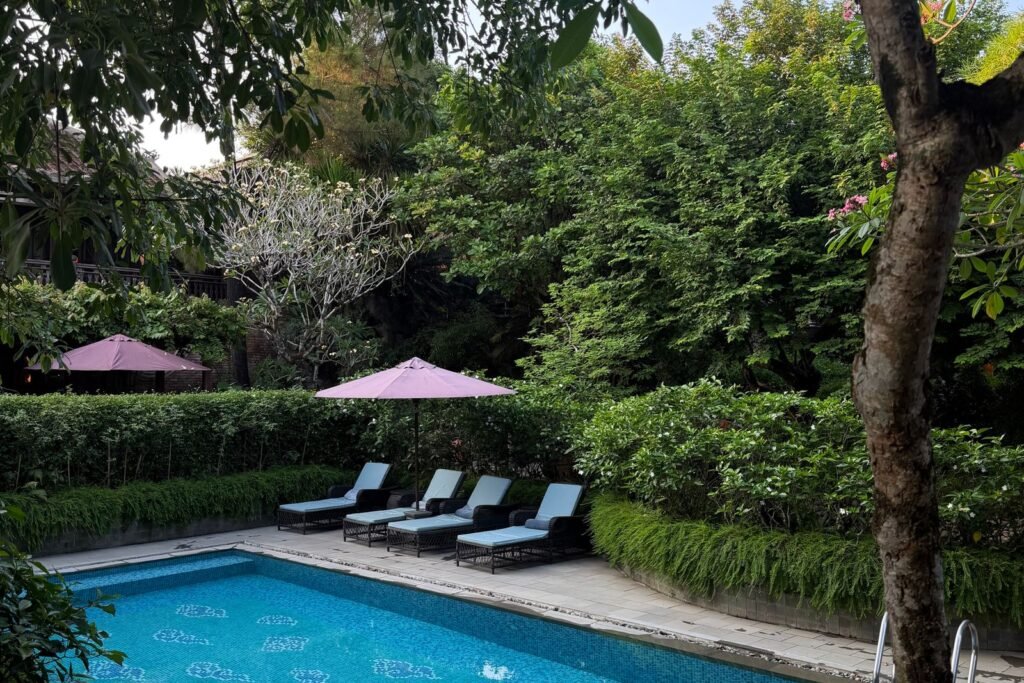 Piscine de jardin bordée de transats