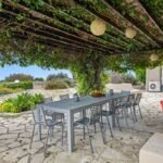 Terrasse de jardin abritée sous une pergola couverte de végétation