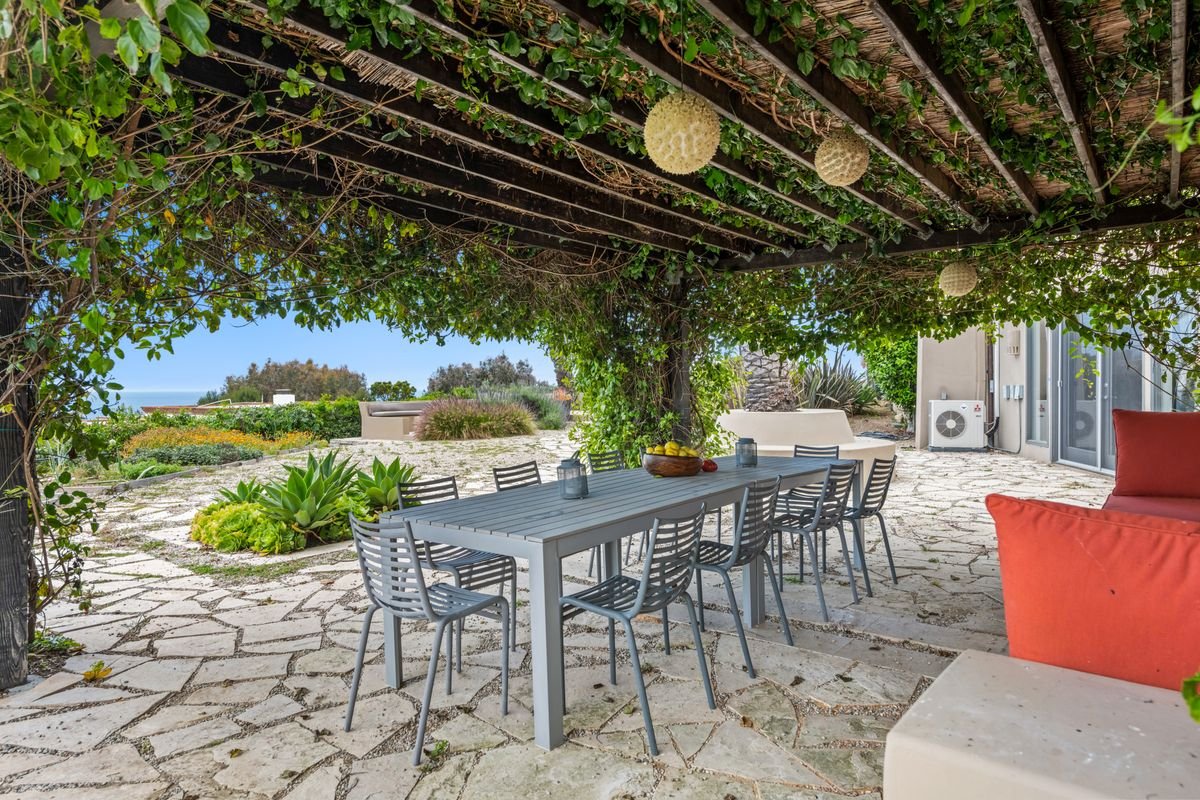 Terrasse de jardin abritée sous une pergola couverte de végétation