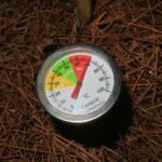Jardinier brassant un tas de compost à la fourche pour l'aérer