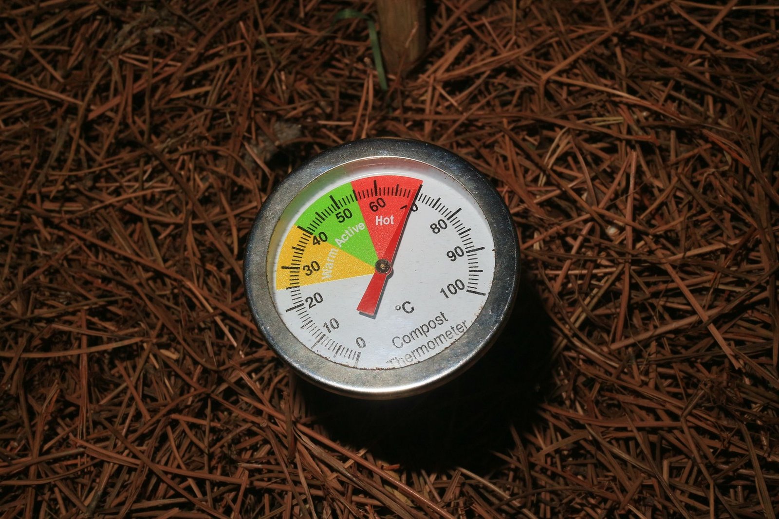 Jardinier brassant un tas de compost à la fourche pour l'aérer