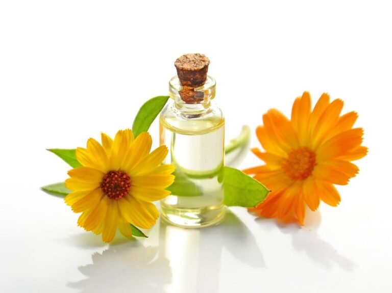 Flacon d’huile entouré de fleurs de calendula